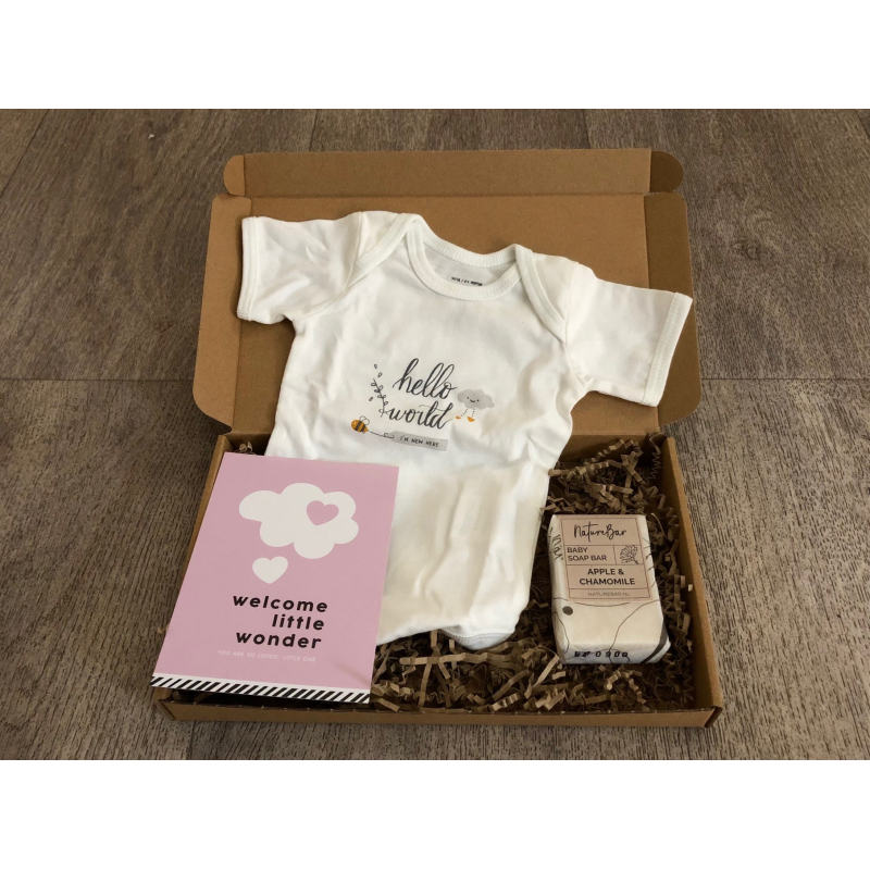 Brievenbuspakketje met rompertje, zeep voor de baby en roze kaart.